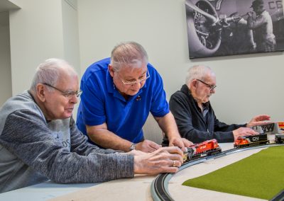Three men put the CN model train on the track