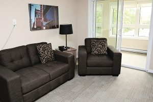A typical living room setup consisting of a loveseat, end table, and chair in one of the Rotary Villas suites