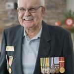 A veteran and resident of Rotary Villas poses with his medals