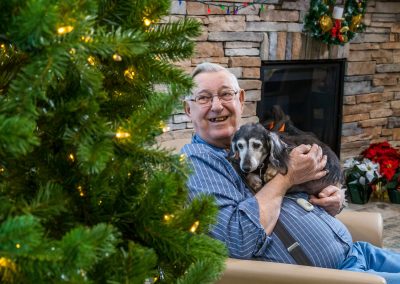 A man and his dog admire the Christmas tree